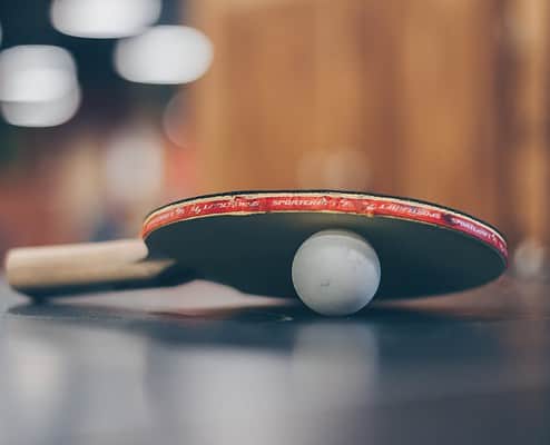 selective focus photo of table tennis ball and ping pong racket