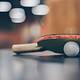 selective focus photo of table tennis ball and ping pong racket